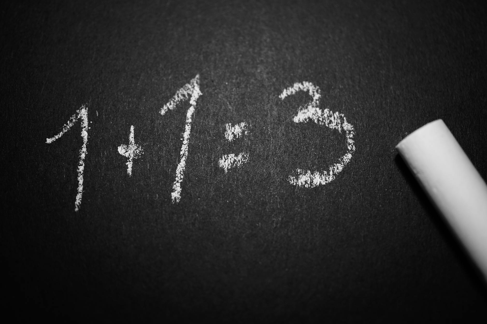 Chalkboard showing incorrect math equation: 1 + 1 = 3, highlighting common math errors.