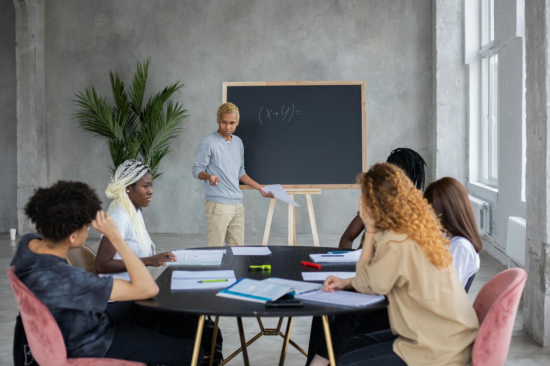 Math tutor instructing a diverse group of students in a collaborative learning environment.